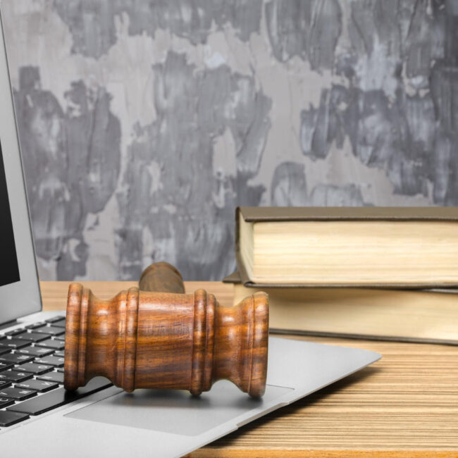 Młotek sędziowski leżący na laptopie