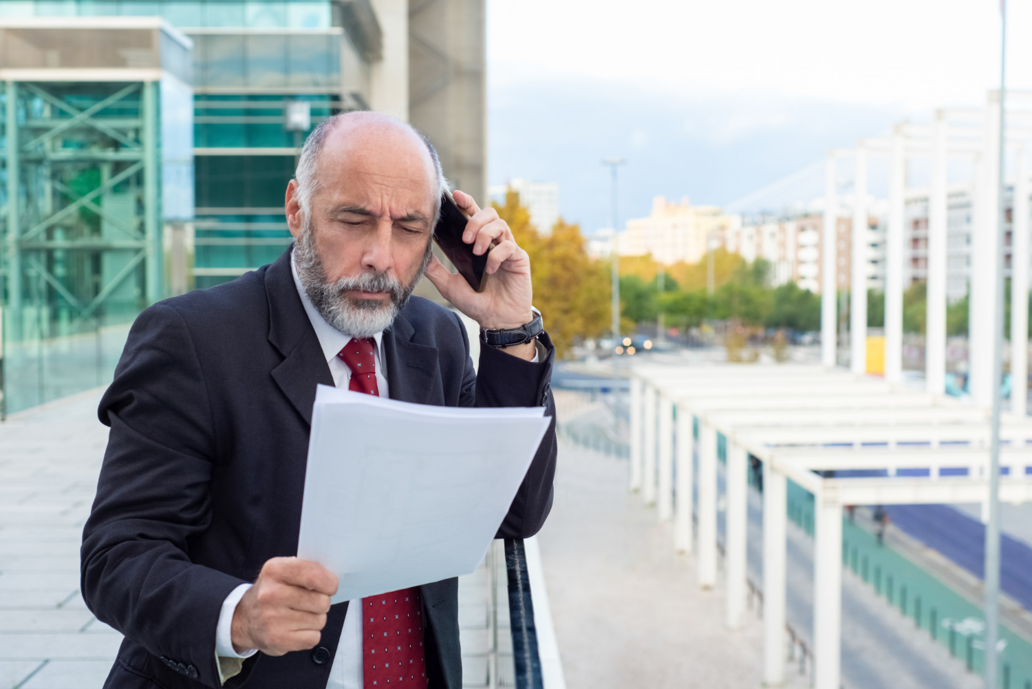 Mężczyzna trzyma dokumenty i rozmawia przez telefon